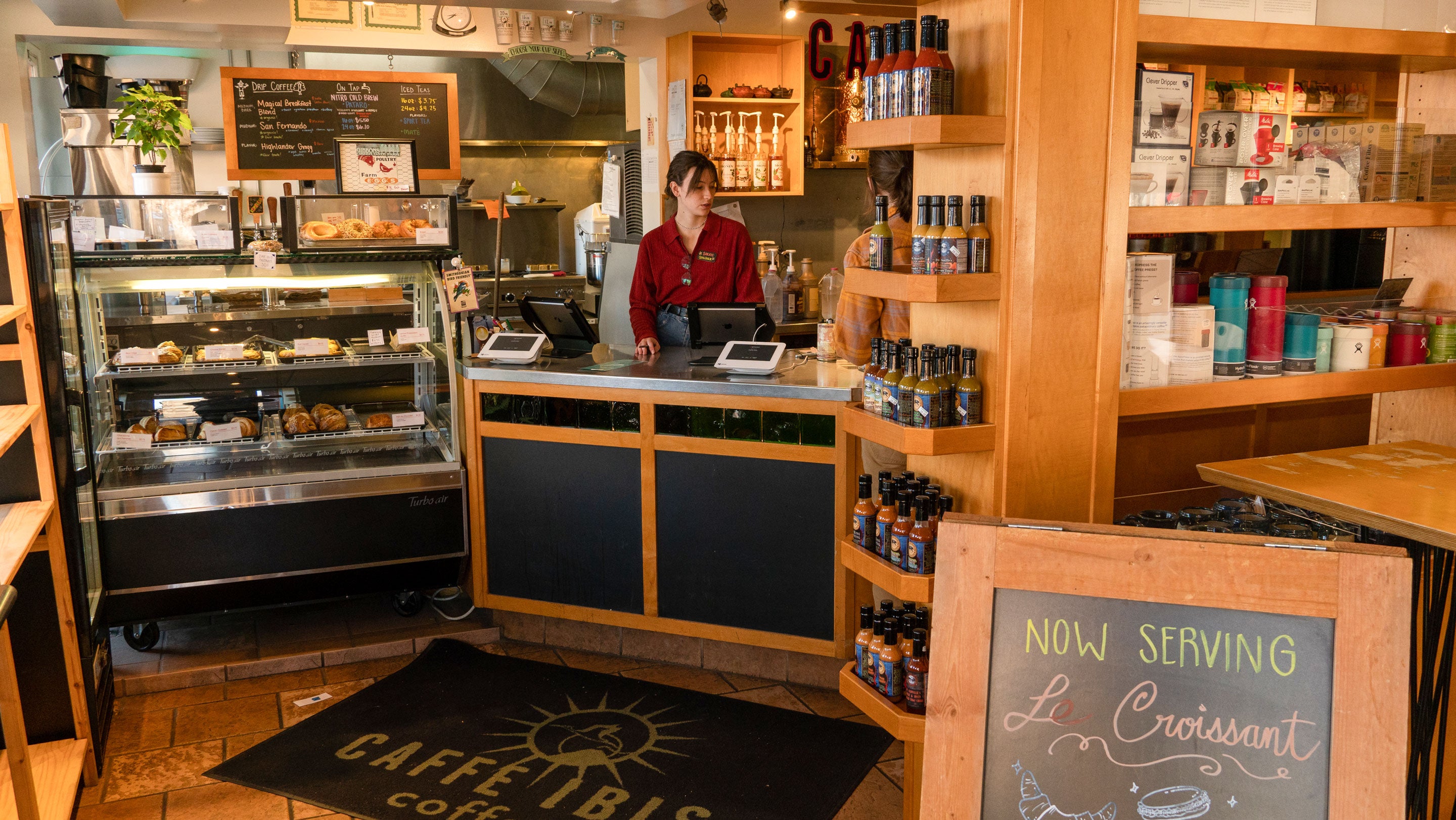 View of Caffe Ibis Cafe Gallery after walking through front door; barista standing behing counter ready to help.