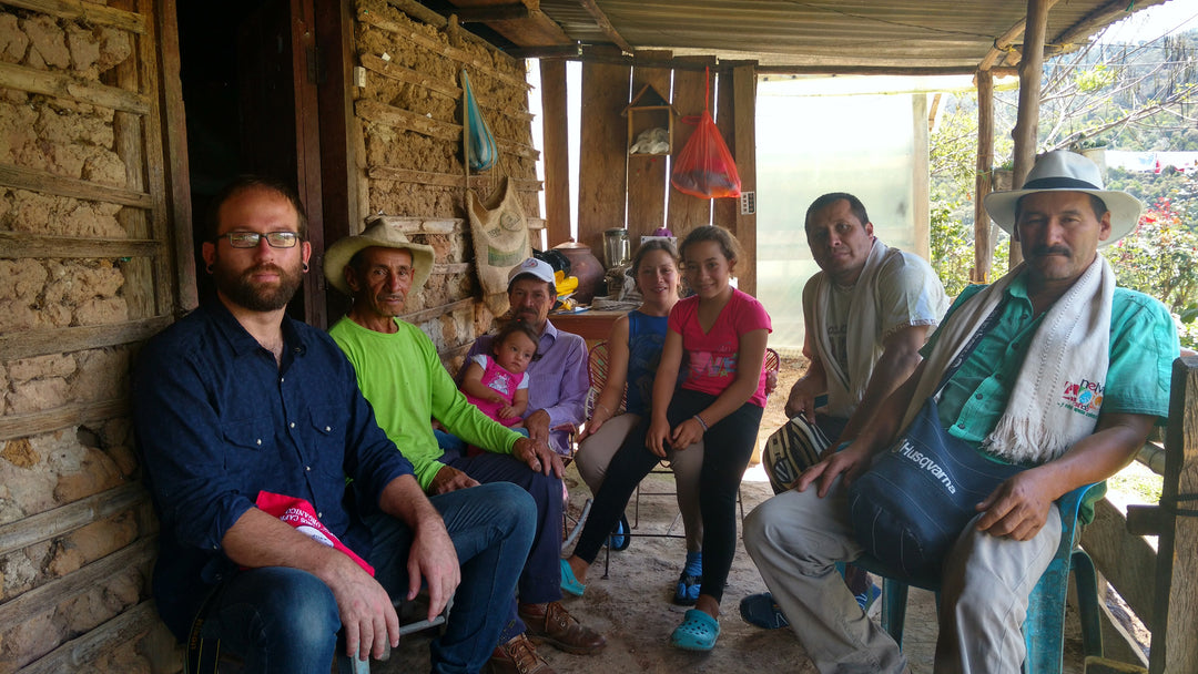 Caffe Ibis roaster, Brandon, pictured sitting next to group of coffee producers in Colombia.