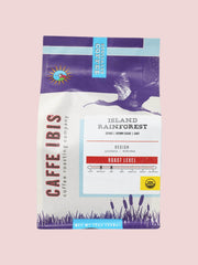 Caffe Ibis Organic Island Rainforest coffee in a purple twelve ounce bag; front view.