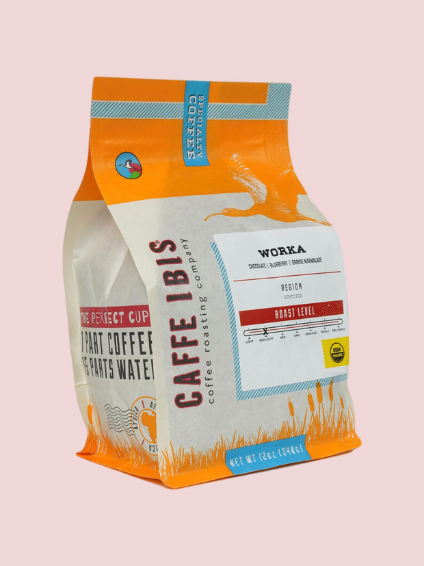 Caffe Ibis Organic Worka in an orange twelve ounce bag; front quarter view.
