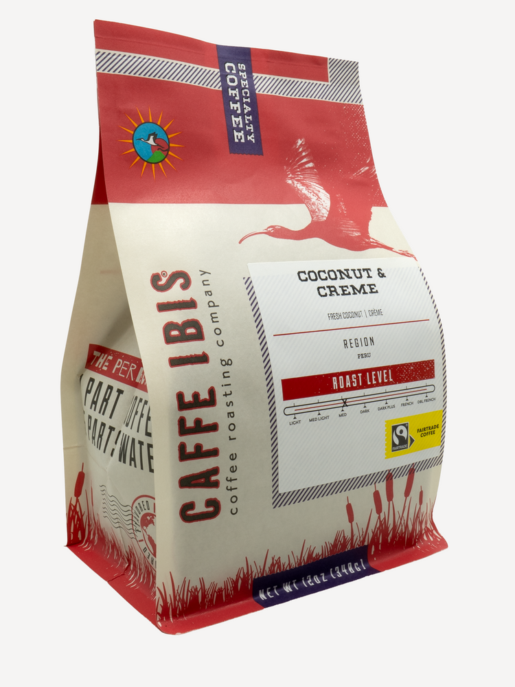 Caffe Ibis Coconut & Creme flavored coffee in a red twelve ounce bag; front quarter view.