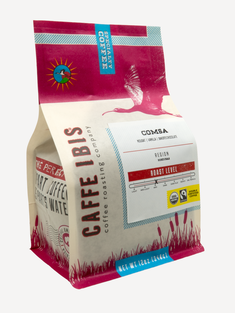 Caffe Ibis Organic Comsa in a pink twelve ounce bag; front quarter view.