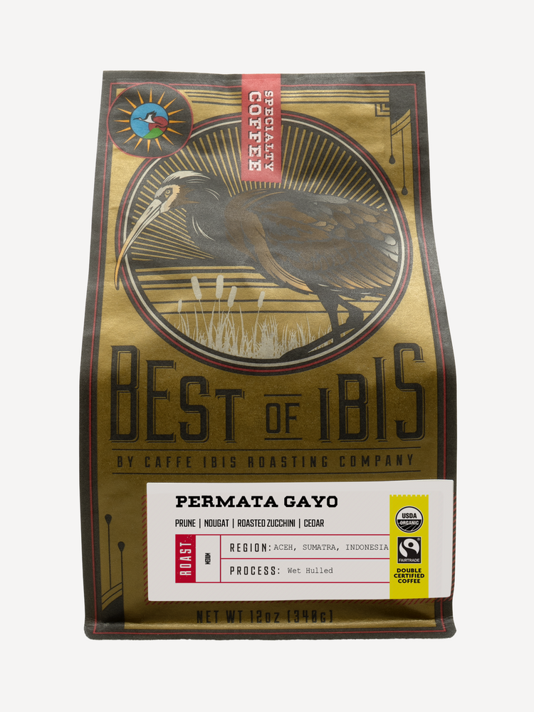 A 12 oz bag of Best of Ibis Roasting Company Permata Gayo coffee, featuring a gold and brown illustrated design with a white-faced Ibis bird and a white label at the bottom.