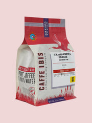 Caffe Ibis flavored Cranberry and Creme coffee in a pink twelve ounce bag; front quarter view.