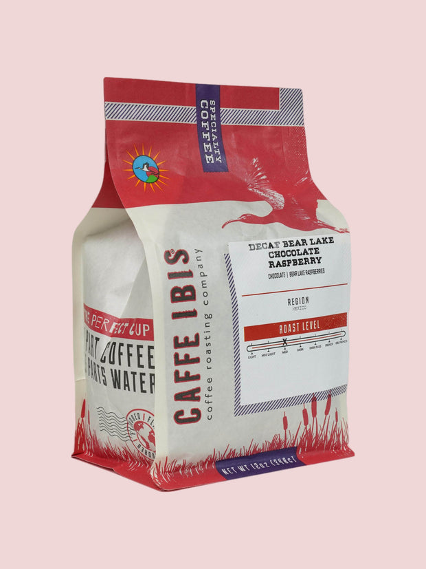 Caffe Ibis Decaf Bear Lake Chocolate Raspberry flavored coffee in a pink twelve ounce bag; front quarter view.
