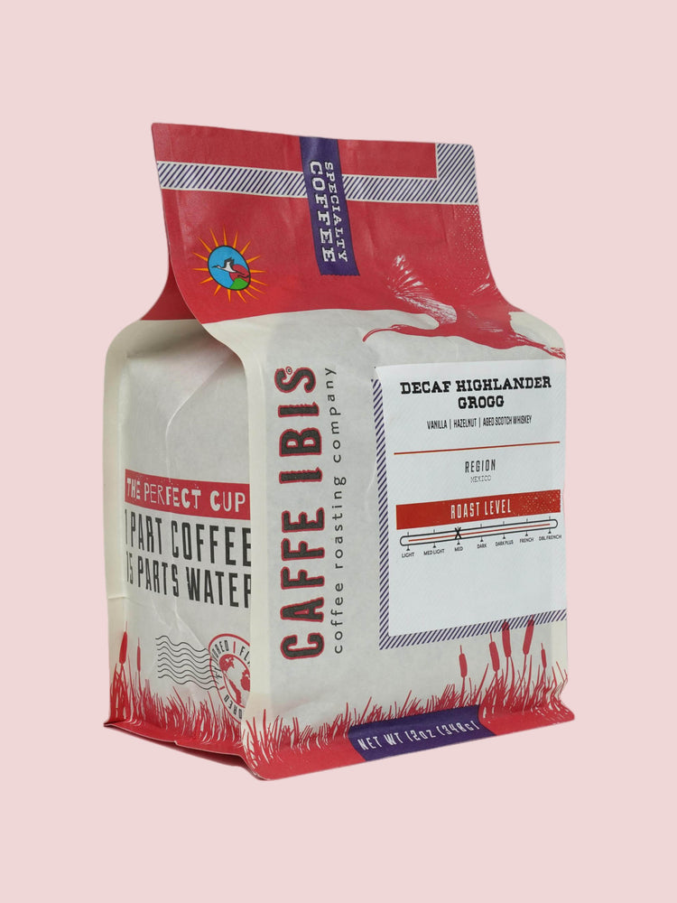 Caffe Ibis Decaf Highlander Grogg flavored coffee in a pink twelve ounce bag; front quarter view.