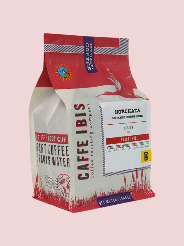 Caffe Ibis flavored Horchata coffee in a pink twelve ounce bag; front quarter view.