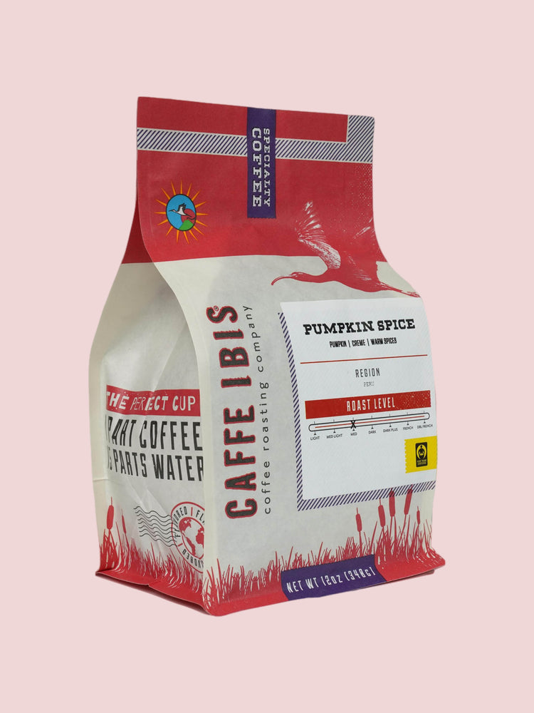 Caffe Ibis seasonal flavored Pumpkin Spice coffee in a pink twelve ounce bag; front quarter view.