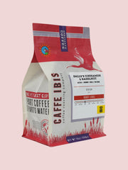 Caffe Ibis flavored sally's cinnamon hazelnut and cream coffee in a pink twelve ounce bag; front quarter view.