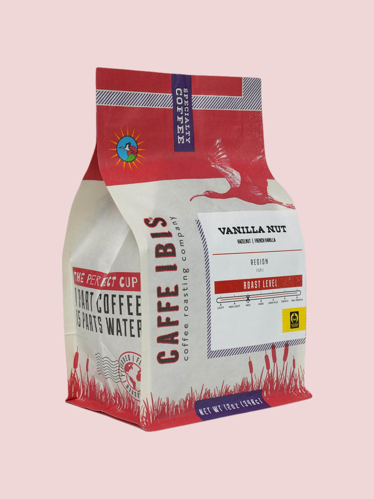 Caffe Ibis flavored Vanilla Nut coffee in a pink twelve ounce bag; front quarter view.
