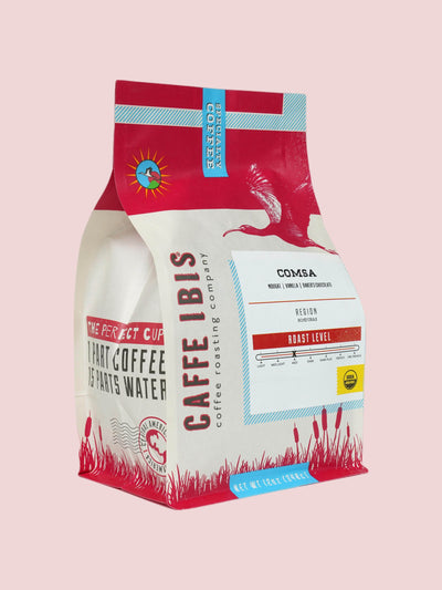 Caffe Ibis Organic Comsa coffee in a red twelve ounce bag, front quarter view.