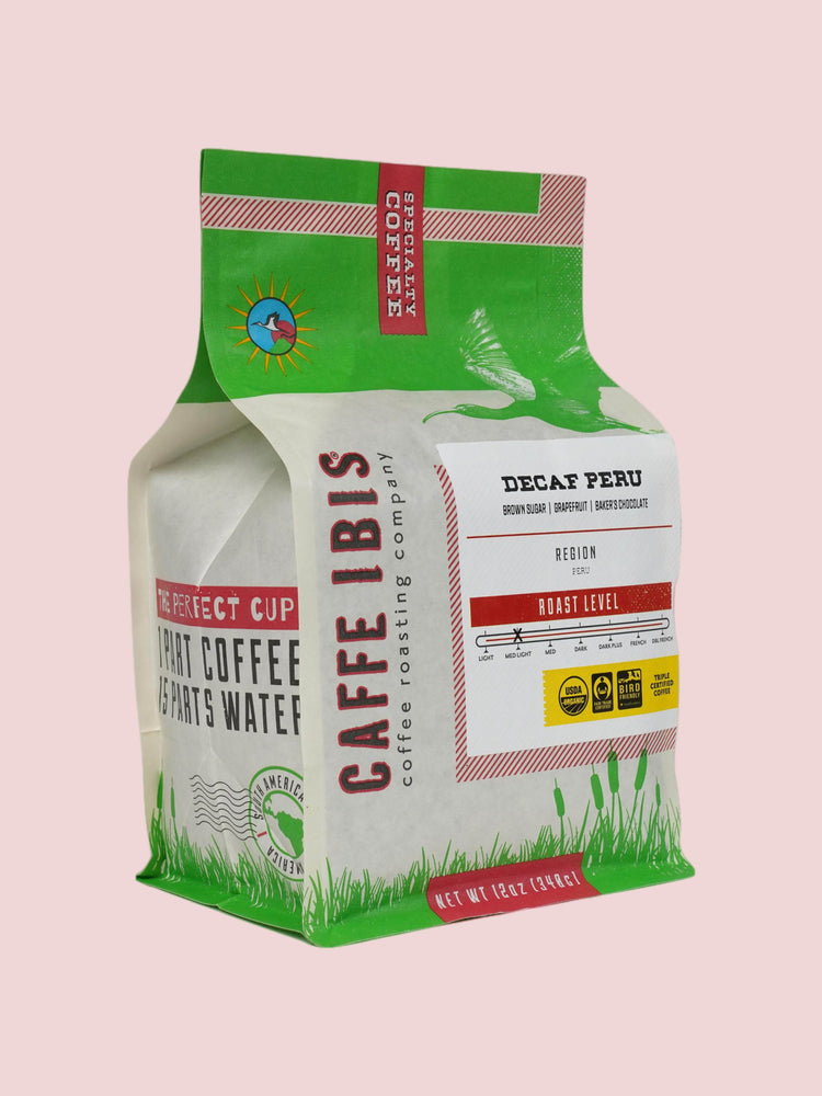 Caffe Ibis Decaf Organic Peru coffee in a green twelve ounce bag; front quarter view.