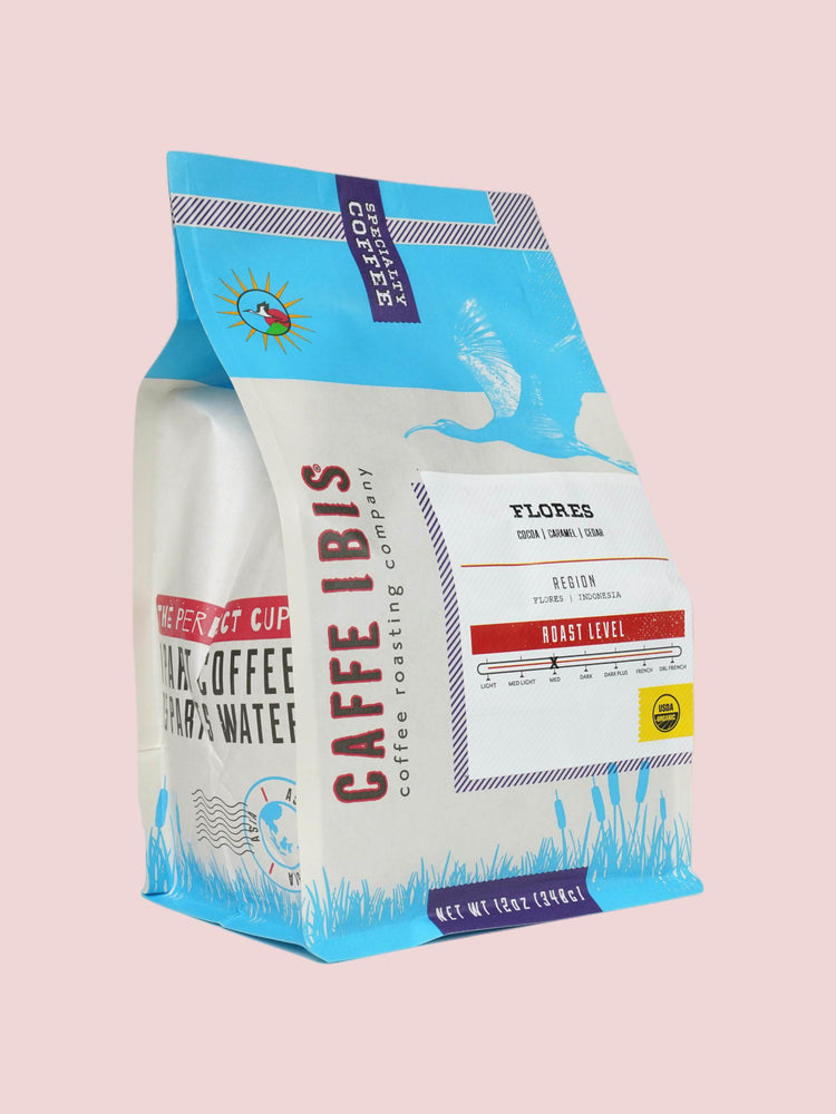 Caffe Ibis Organic Flores coffee in a blue twelve ounce bag; front quarter view.