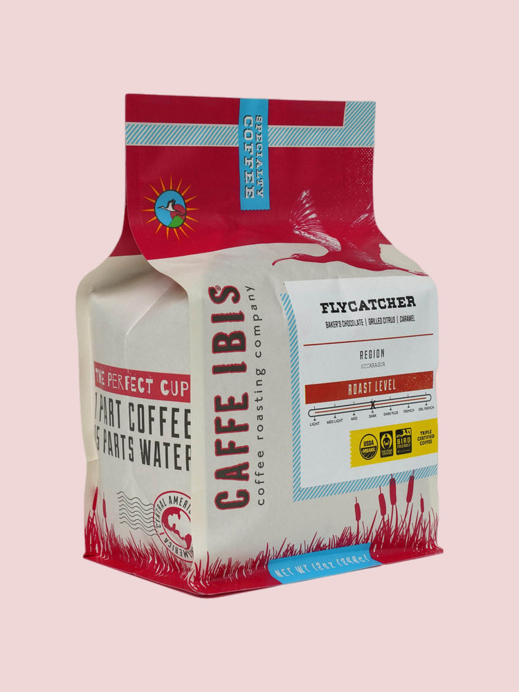 Caffe Ibis Organic Flycatcher coffee in a red twelve ounce bag; front quarter view.
