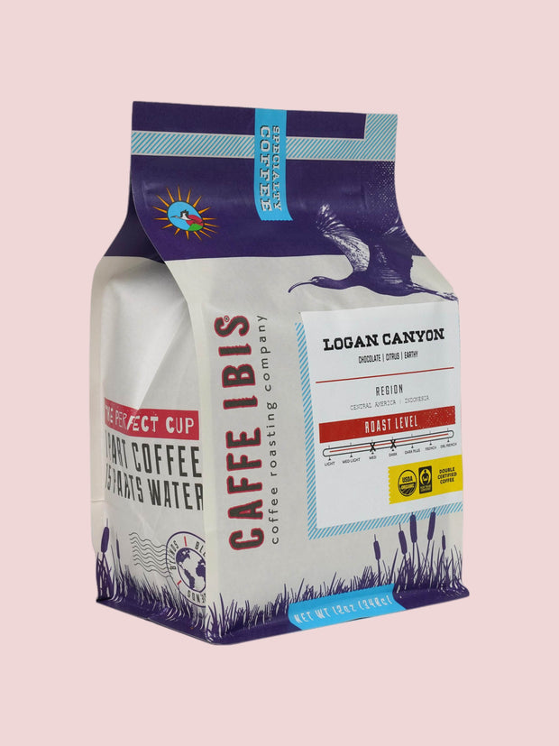 Caffe Ibis organic Logan Canyon blend coffee in a purple twelve ounce bag; front quarter view.